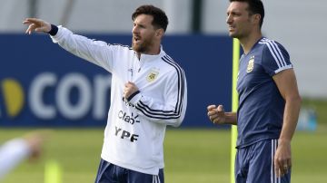 Lionel Messi (L) y Lionel Scaloni (R) conversan durante un entrenamiento de la selección Argentina.