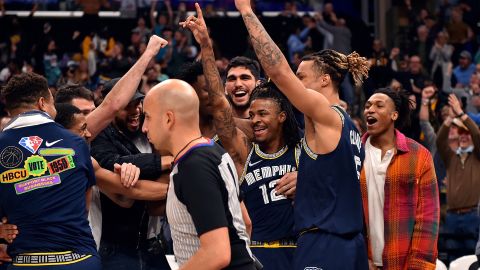 JA Morant (#12) celebra junto a sus compañeros de equipo la cesta.