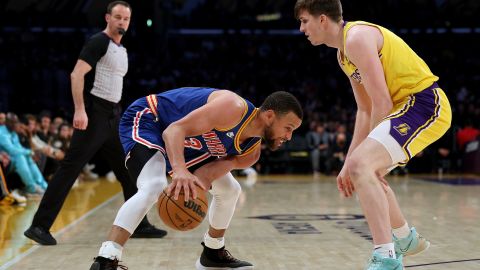 Stephen Curry (L) es marcado por Austin Reaves (R) segundos antes del tiro de fantasía.