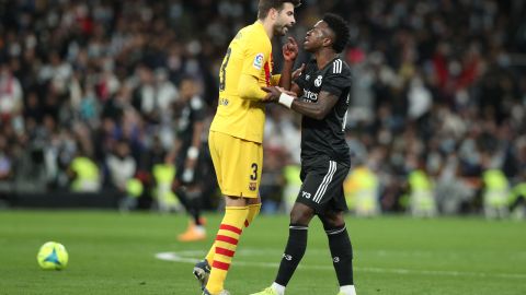 Gerard Piqué (L) le reclama una jugada a Vinicius Jr. (R) en El Clásico de España entre Real Madrid y Barcelona.