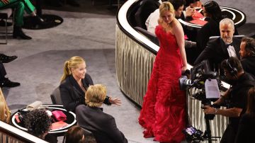 Amy Schumer en el momento que para a la actriz Kirsten Dunst de su asiento en los Oscar 2022.