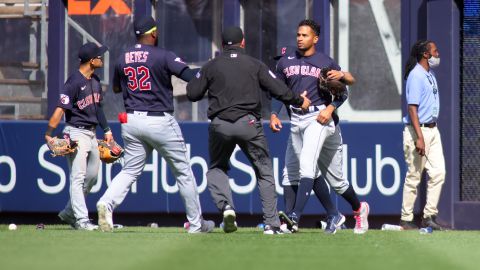 Jardineros de Cleveland Guardians corren para intentar protegerse de los proyectiles lanzados por los fanáticos de los Yankees.