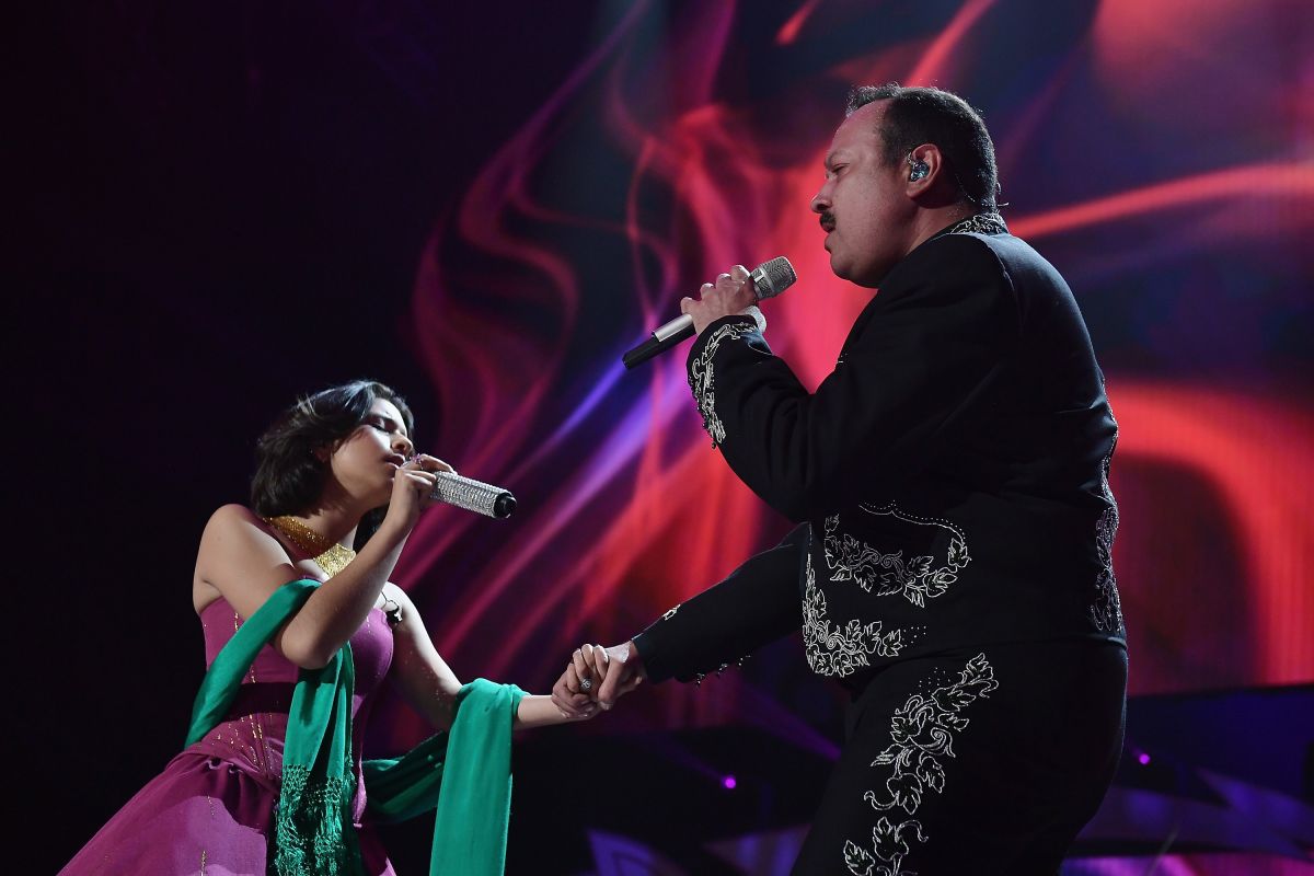 Ángela Aguilar toma la mano de su padre, el cantante Pepe Aguilar. 