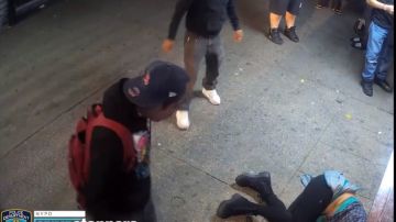 La víctima en el suelo, frente a atacantes y observadores.