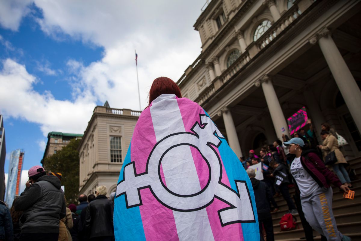 Manifestante con una bandera del orgullo trans.