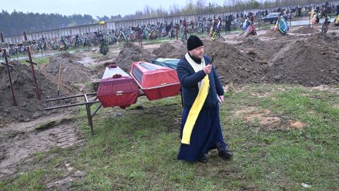 Sacerdote ortodoxo en funeral de una familia asesinada en Bucha, en las afueras de Kiev.