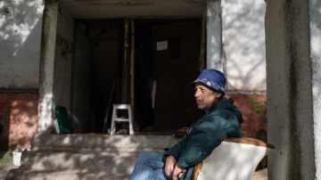 Un ciudadano ucraniano se sienta junto a la entrada de su bloque de apartamentos que ahora se encuentra en estado de emergencia.