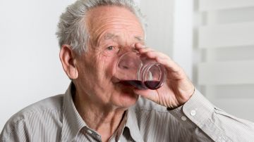 Adulto mayor bebiendo alcohol