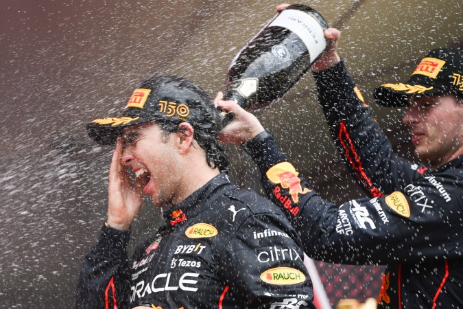Max Verstappen (R) baña con champaña a Checo Pérez en el podio del Gran Premio de Mónaco. EFE/EPA/CHRISTIAN BRUNA