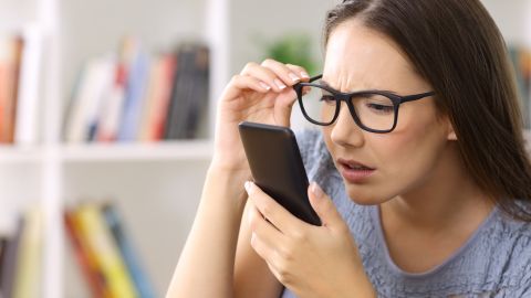 Girl,Wearing,Eyeglasses,With,Eyesight,Problems,Trying,To,Read,Phone