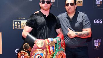 Canelo Álvarez (L) y Eddy Reynoso (R) posan con sus cinturones en la rueda de prensa de presentación de la tercera pelea ante Gennady Golovkin.