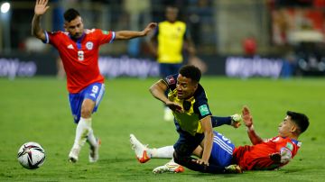 Byron Castillo es derribado por el chileno Claudio Baeza durante un encuentro entre Ecuador y Chile por las eliminatorias hacia Qatar 2022.