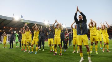 Jugadores de Ucrania saludan a sus fanáticos tras la victoria ante Escocia.