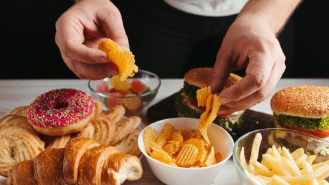 Hombre comiendo alimentos chatarra
