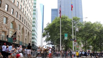 Vista de la bandera colombiana izada junto a la estadounidense, por el día de la Independencia del país latinoamericano, este miércoles junto a la estatua del toro de Wall Street en Nueva York.