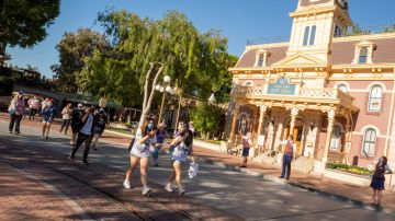 Visitantes de Disneyland caminan por Main Street, U.S.A.