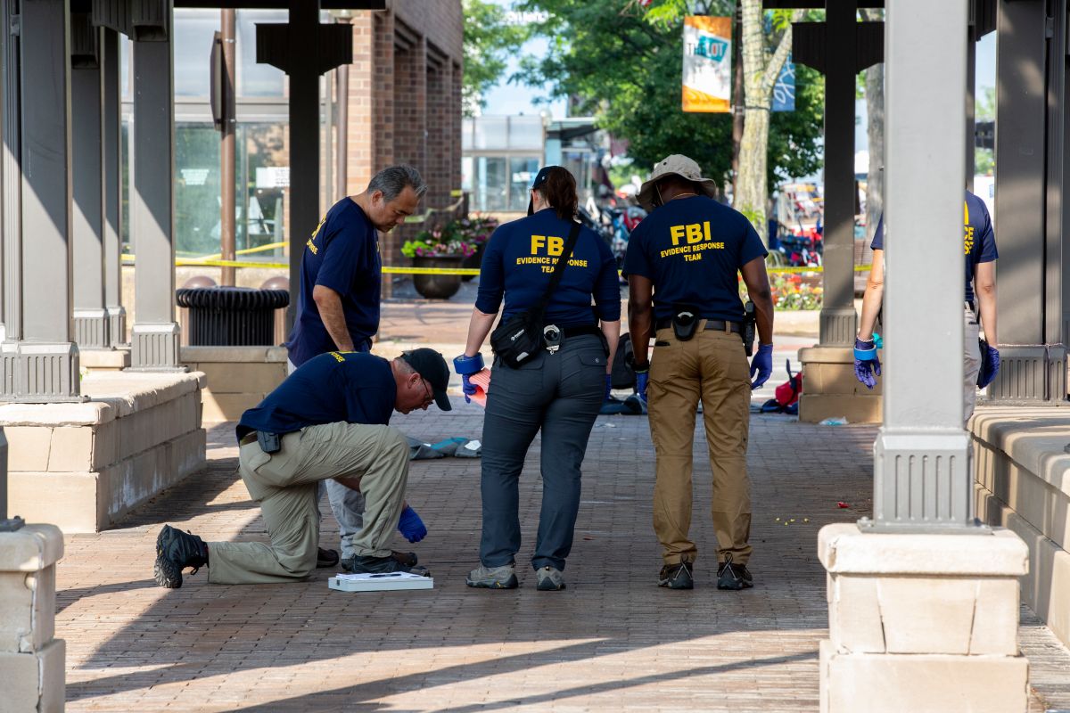 Agentes del FBI examinan la escena del tiroteo en Highland Park, Illinois.  