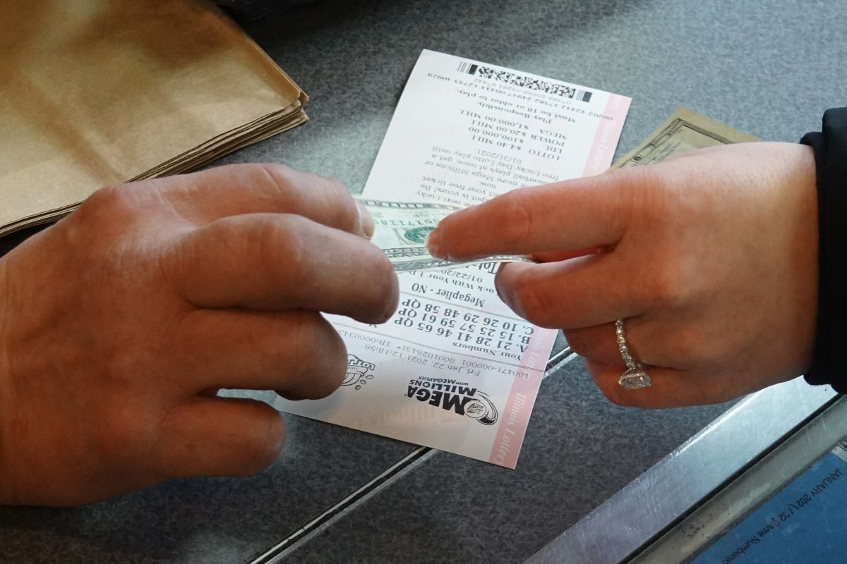 Un cliente en Chicago paga por un boleto de lotería de Mega Millions.