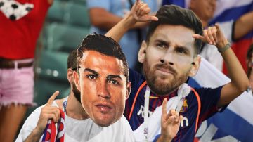 Fanáticos de Cristiano Ronaldo (L) y Lionel Messi (R) muestran figuras con su rostro durante un encuentro del Mundial de Rusia 2018.