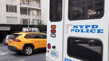 Taxi y unidad de NYPD en calle de Nueva York.