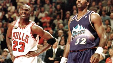 Michael Jordan (L) sonríe durante un tiro libre junto a Karl Malone (R) en las Finales de la NBA en 1998.