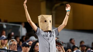 Un seguidor de los Yankees con la cabeza cubierta con una bolsa de papel muestra su frustración por la derrota de Yankees ante Toronto Blue Jays.