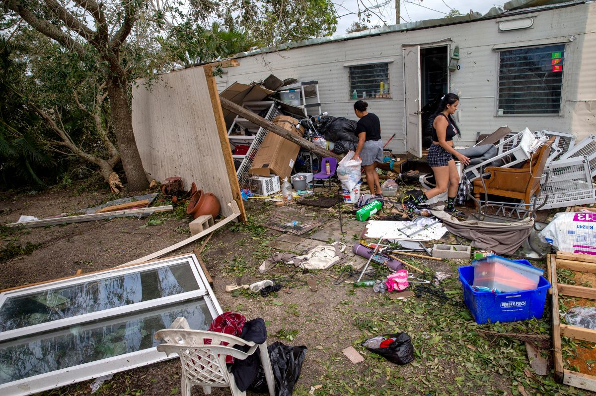 Residentes de una casa móvil en Fort Myers, Florida, examinan los daños provocados por el huracán Ian.