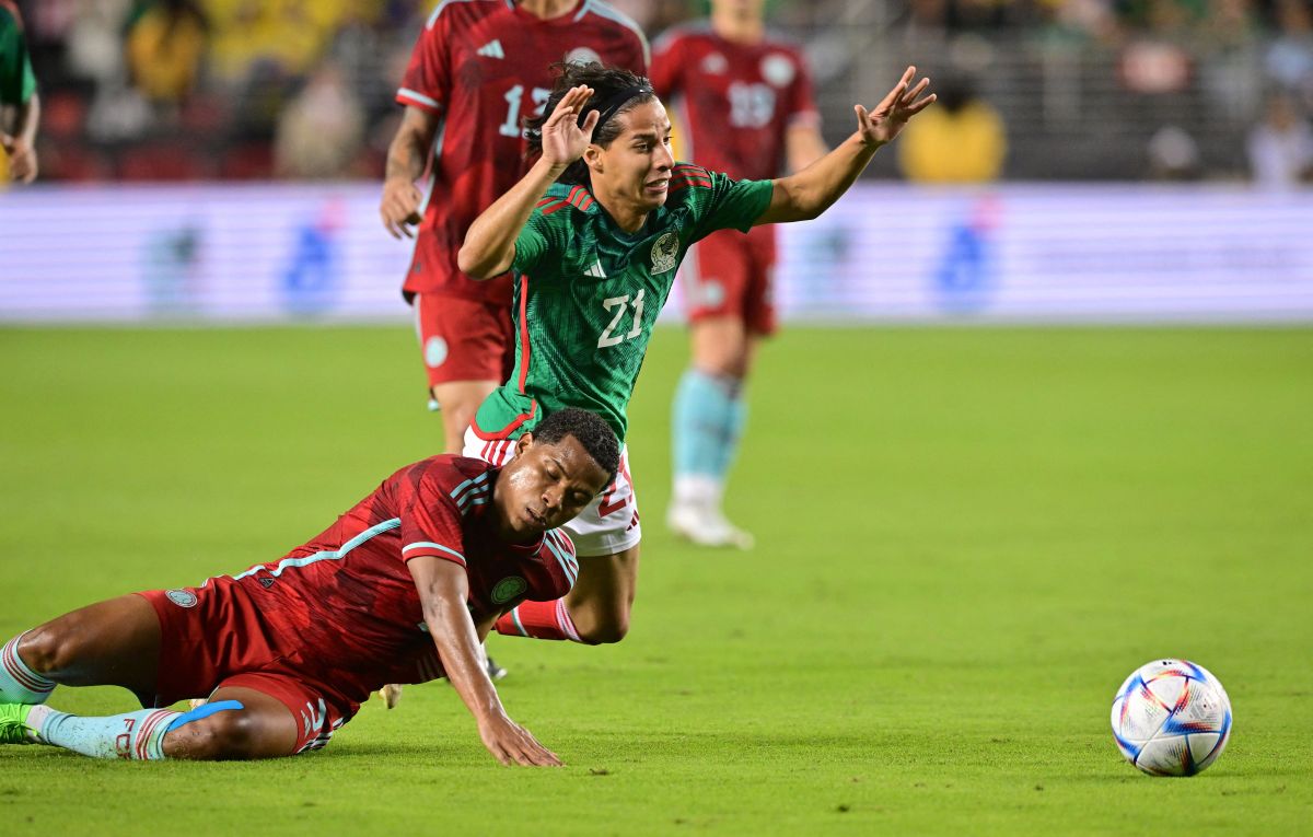 Diego Lainez (R) recibe una falta por parte de Wilmar Barros (L) en el amistoso entre México y Colombia.