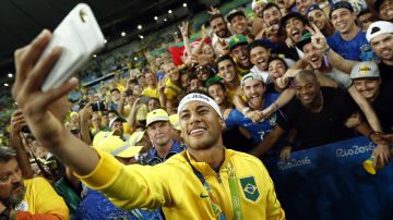 Neymar posa con unos aficionados luego de ganar la medalla de oro para Brasil en los Juegos Olímpicos de Río de Janeiro 2016.