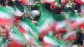 Iranian women wave national flags during