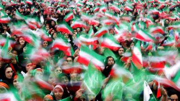 Iranian women wave national flags during