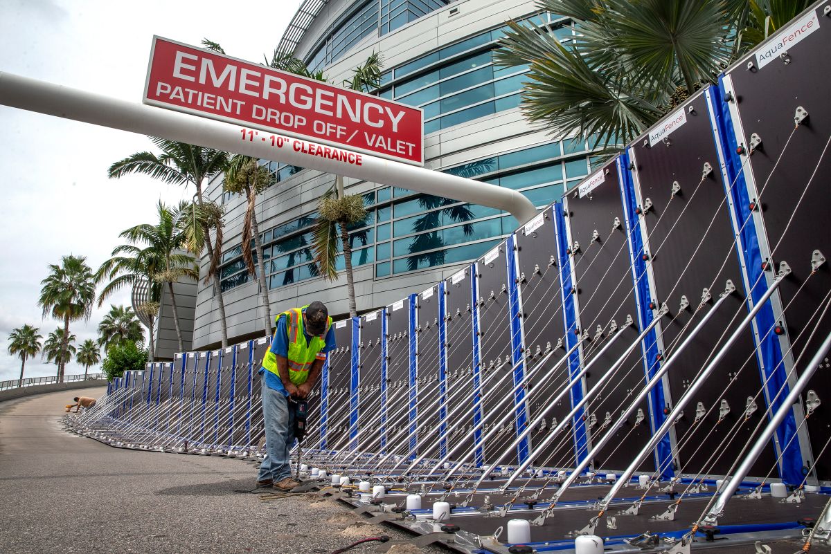 Un trabajador levanta una barrera de seguridad en el Hospital General de Tampa en Florida donde este miércoles se espera el impacto del huracán Ian.