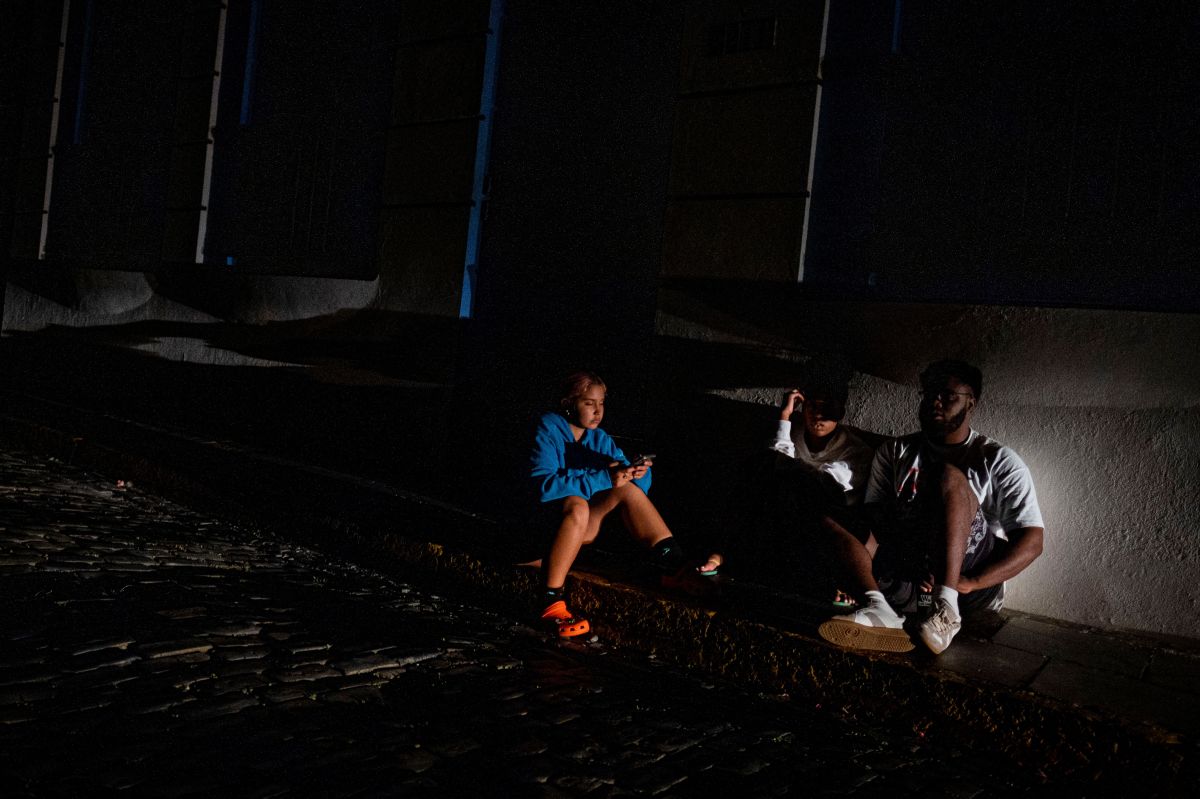 Puertorriqueños a oscuras en una calle del Viejo San Juan por un apagón en junio del año pasado.