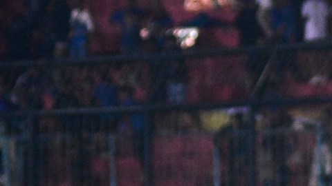 Fanáticos buscan socorrer a un afectado por los gases lacrimógenos.