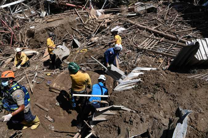 Members of a rescue team search through the rubble of destroyed houses for victims or survivors after a landslide during heavy rains in Las Tejerias, Aragua state, Venezuela, on October 10, 2022. - A landslide in central Venezuela left at least 22 people dead and more than 50 missing after heavy rains caused a river to overflow, Vice President Delcy Rodriguez said Sunday. (Photo by Yuri CORTEZ / AFP)