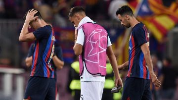 Jugadores del FC Barcelona abandonan visiblemente frustrados el terreno de juego.