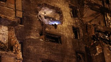 Bomberos miran desde un edificio parcialmente destruido después de que un avión militar Sukhoi Su-34 se estrellara en una zona residencial de Yeysk.