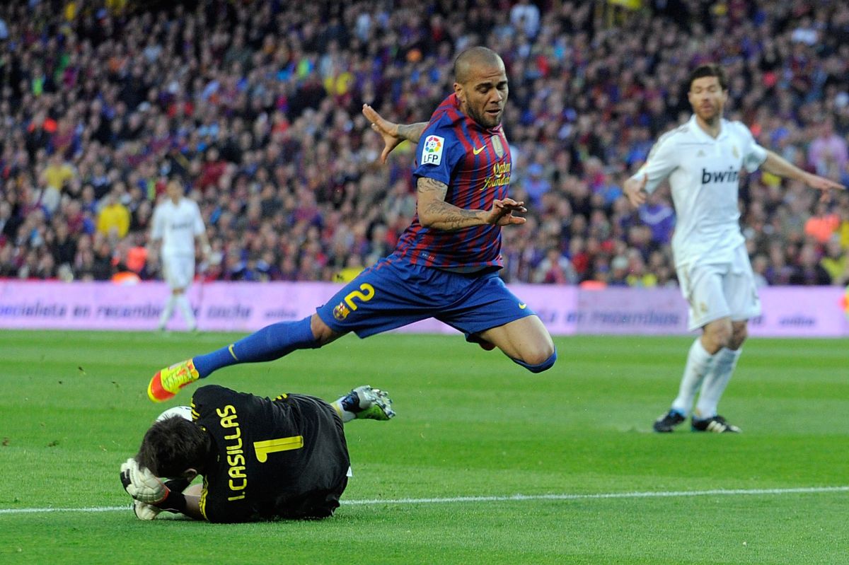 BARCELONA, SPAIN - APRIL 21: Dani Alves (R) of FC Barcelona is tackled by Iker Casillas of Real Madrid CF during the La Liga match between FC Barcelona and Real Madrid CF at Camp Nou on April 21, 2012 in Barcelona, Spain.  (Photo by Denis Doyle/Getty Images)