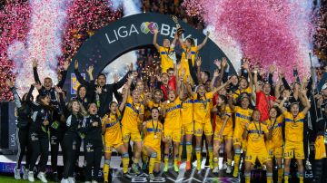 Jugadoras y cuerpo técnico de Tigres celebran con el trofeo de campeonas del Apertura 2022 de la Liga MX Femenil.