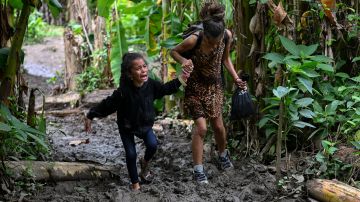 Una niña migrante venezolana es ayudada por su madre cuando llegan a la aldea de Canaan Membrillo, el primer control fronterizo de la provincia de Darién en Panamá.