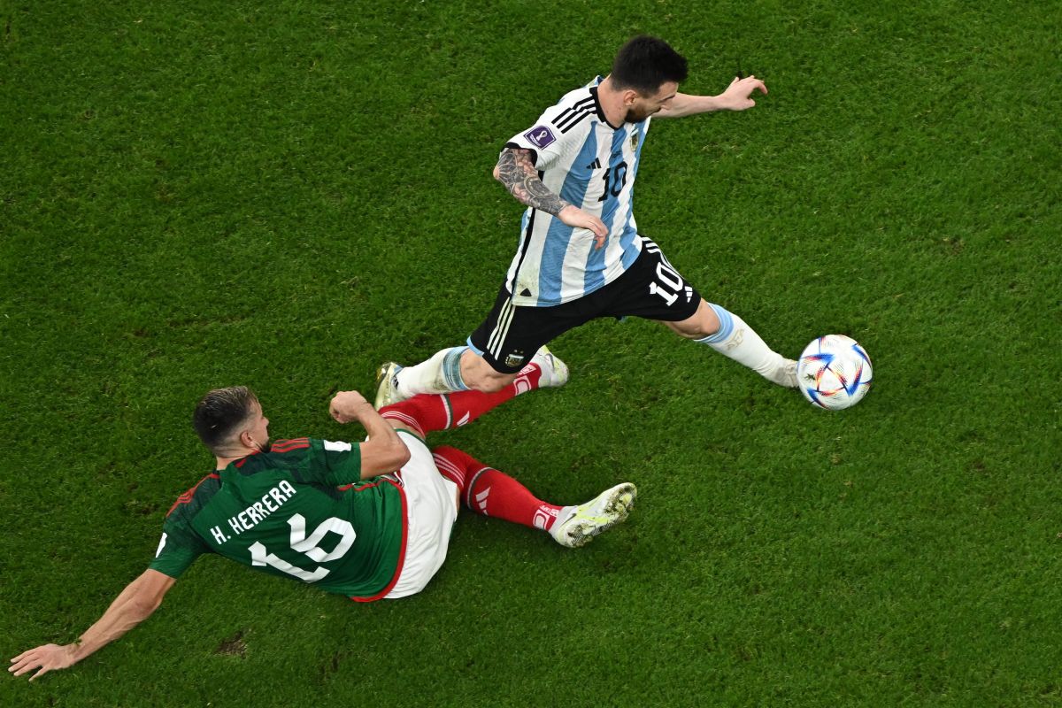 Héctor Herrera (L) y Lionel Messi (R) disputan un balón durante el Argentina vs. México.