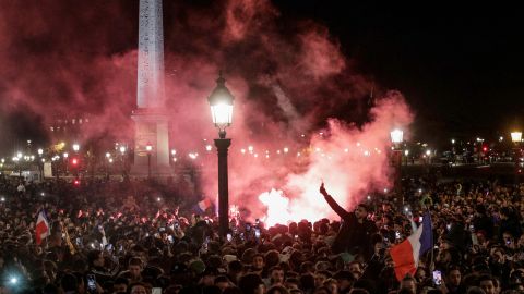 Los fanáticos encienden bengalas mientras esperan en la plaza de la Concordia la llegada de la selección francesa de fútbol.