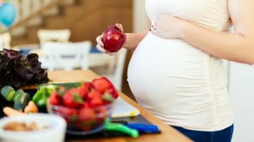 Mujer embarazada eligiendo fruta