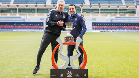 El entrenador del Real Madrid, Carlos Ancelotti (i), y el entrenador del Barcelona, Xavi Hernández (d), posan junto al trofeo de la Supercopa de España, este sábado en el estadio Rey Fahd de Riad.