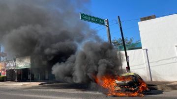 Vista de un vehículo calcinado hoy tras los enfrentamientos de fuerzas federales con grupos armados en Culiacán.