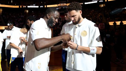 Klay Thompson (L) y Draymond Green (R) reciben los anillos de campeón por el título de Golden State Warriors en 2022.