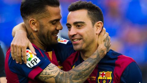 Dani Alves (L) y Xavi Hernández (R) comparten en el FC Barcelona.