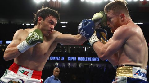 Julio César Chávez Jr. (L) conecta un golpe ante Saúl "Canelo" Álvarez.