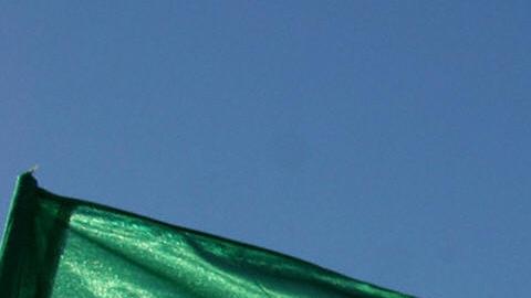 An Iranian flag flutters next to a groun