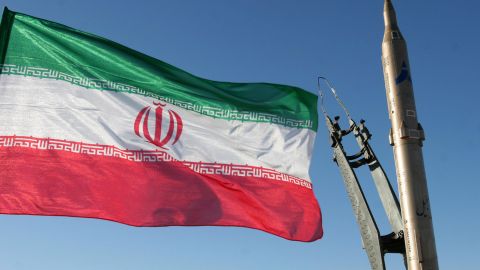 An Iranian flag flutters next to a groun